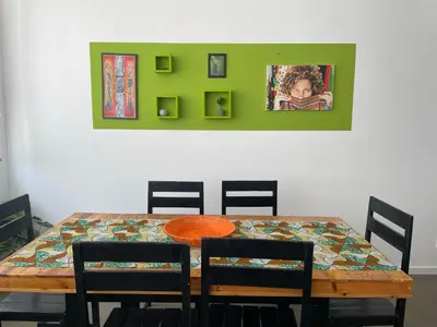 a dining room table with four chairs and a colorful tablecloth at Tia Nita Apartamentos in Mindelo