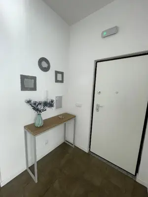 a room with a table and a white wall at Tia Nita Apartamentos in Mindelo