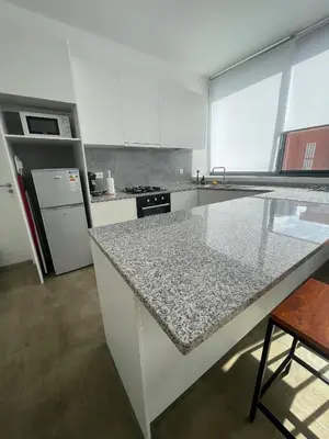 a kitchen with white cabinets and a granite counter top at Tia Nita Apartamentos in Mindelo