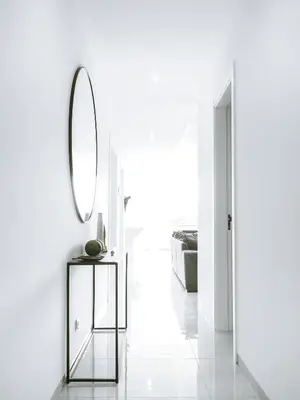 a white hallway with a mirror and a table at Filomena Apartments LUXURY in Mindelo