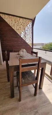 a wooden table with a bench and a wooden table and chair at Casa Visto Mar in Sal Rei