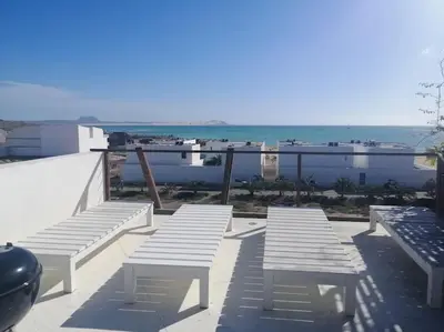 a group of white benches sitting on top of a building at Casa Visto Mar in Sal Rei