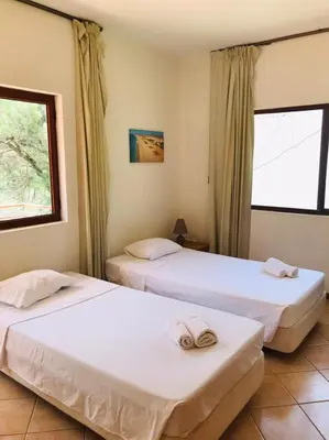 two beds in a room with two windows at Residencial Lela d'Fermina in Pombas