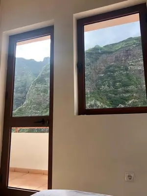 a bedroom with a window with a view of a mountain at Residencial Lela d'Fermina in Pombas