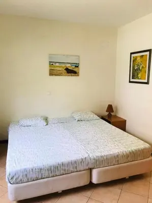 a bedroom with a bed and a painting on the wall at Residencial Lela d'Fermina in Pombas