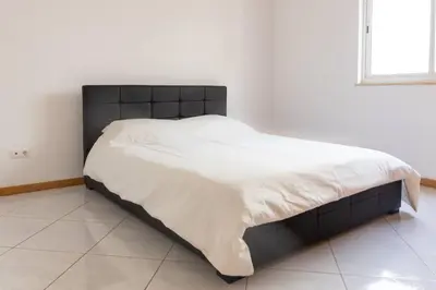 a bed with a black headboard in a bedroom at 3 bedroom apt, Exterior POOL , Cidadela - LCGR in Praia