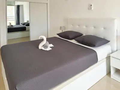 a bedroom with a large bed with a swan on it at 3 bedroom apt, FREE WIFI & AC, Cidadela - LCGR in Praia