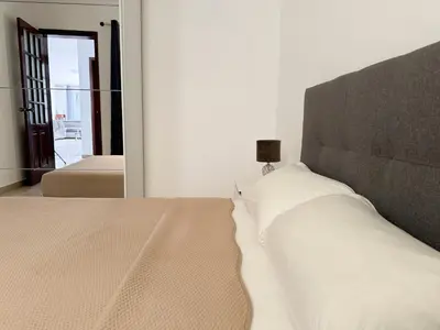 a bedroom with a large bed with a large mirror at 3 bedroom apt, FREE WIFI & AC, Cidadela - LCGR in Praia