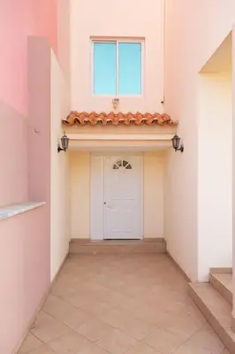a hallway with a white door and a window at 3 bedroom apt, FREE WIFI & AC, Cidadela - LCGR in Praia