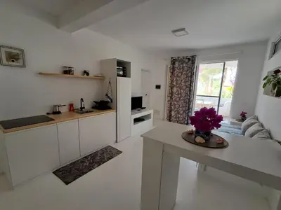 a white kitchen with a table and a couch at Praia de Chaves Bungalow ,Boavista in Sal Rei