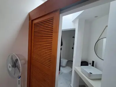 a bathroom with a wooden door and a sink at Praia de Chaves Bungalow ,Boavista in Sal Rei