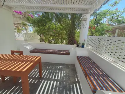 a porch with a wooden bench and a table at Praia de Chaves Bungalow ,Boavista in Sal Rei