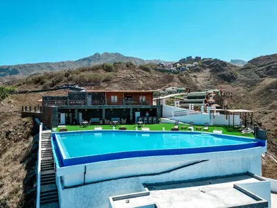 a house with a swimming pool on top of a mountain at RM Green Hotel in Lombo Branco