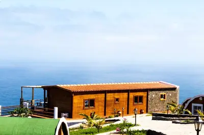 a small house with the ocean in the background at RM Green Hotel in Lombo Branco