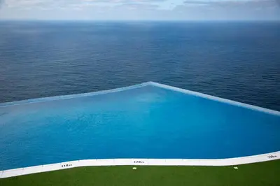 an aerial view of a swimming pool near the ocean at RM Green Hotel in Lombo Branco