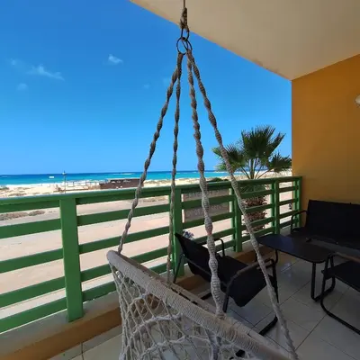 a swing in a room with a view of the beach at Ca Luna Deluxe sun & Beach in Sal Rei