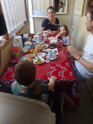 a group of people sitting around a table eating food at Casa de Férias in Tarrafal