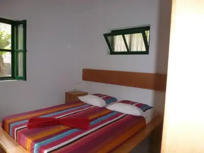 a bedroom with a bed with a colorful striped blanket at Cottage na Ribeira do Paúl in Pombas