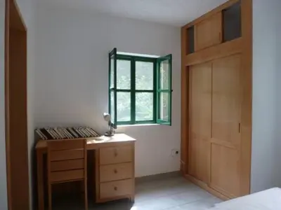a bedroom with a wooden dresser and a window at Cottage na Ribeira do Paúl in Pombas