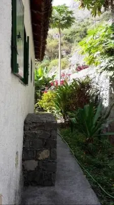 a walkway next to a building with a stone wall at Cottage na Ribeira do Paúl in Pombas