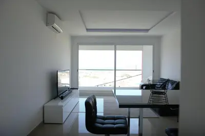 a room with a desk and chairs and a large window at Duarte Apartments - Vista in Mindelo