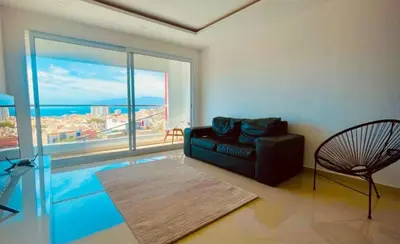 a living room with a couch and a large window at Duarte Apartments - Vista in Mindelo
