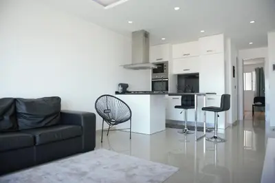 a living room with a black couch and a kitchen at Duarte Apartments - Vista in Mindelo