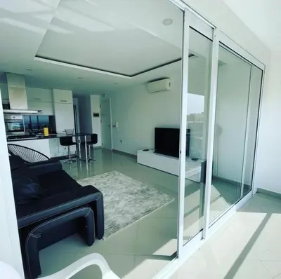 a living room with a black couch and a kitchen at Duarte Apartments - Vista in Mindelo