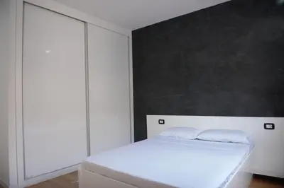 a bedroom with a white bed and a black wall at Duarte Apartments - Vista in Mindelo