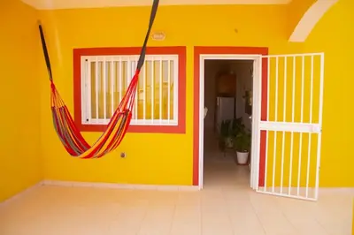 a room with two hammocks hanging from a yellow wall at Cosy & Relax Yellow House 5mn walk from the beach! in Calheta Do Maio