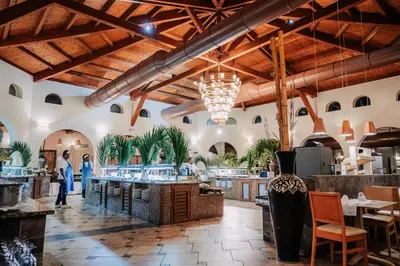 a restaurant with wooden ceilings and tables and chairs at VOI Praia de Chaves Resort in Sal Rei