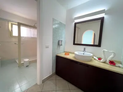 a bathroom with a sink and a mirror and a shower at VOI Praia de Chaves Resort in Sal Rei