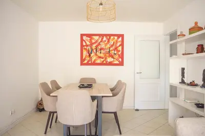 a dining room with a table and chairs at 2 bdr cozy beachside apartment, Copacabana - LCGR in Mindelo