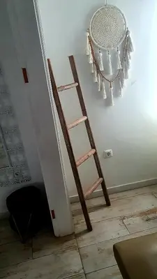 a wooden ladder leaning against a wall with a chandelier at As Hortênsias in Mindelo
