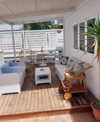 a screened in porch with a couch and a table at As Hortênsias in Mindelo