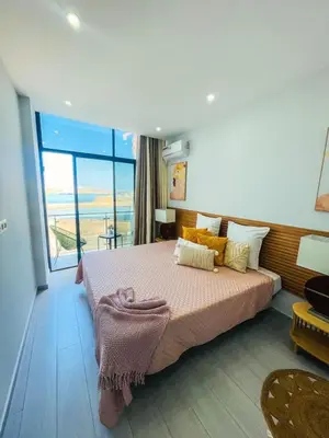 a bedroom with a large bed and a large window at Résidence Cazino Apartamentos in Praia