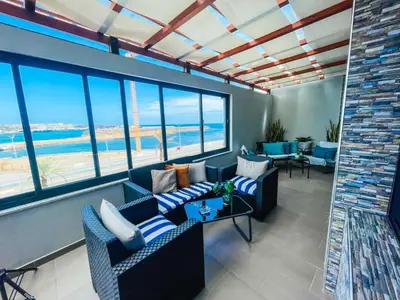 a living room with couches and a view of the ocean at Résidence Cazino Apartamentos in Praia