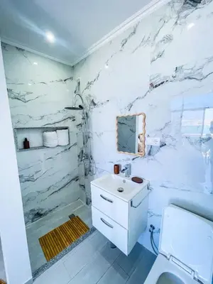 a bathroom with a white marble wall at Résidence Cazino Apartamentos in Praia
