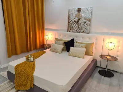 a bedroom with a large white bed with two lamps at Résidence Cazino Apartamentos in Praia