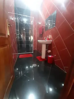 a red bathroom with a sink and a mirror at Tarrafal House in Tarrafal
