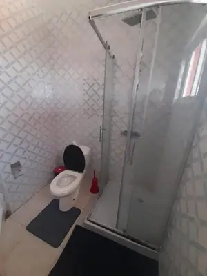 a bathroom with a toilet and a glass shower at Tarrafal House in Tarrafal