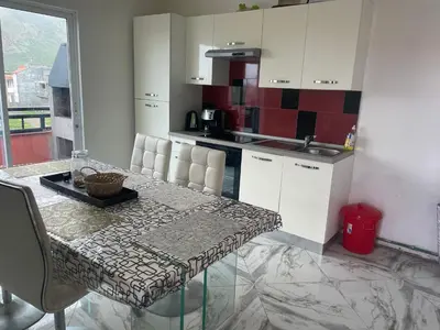 a kitchen with white cabinets and a table with chairs at Tarrafal House in Tarrafal