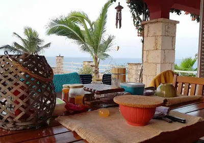 a table on a patio with a view of the ocean at Villa Lagosta Stella Maris Exclusive in Vila do Maio
