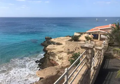 a house on a cliff next to the ocean at Villa Lagosta Stella Maris Exclusive in Vila do Maio