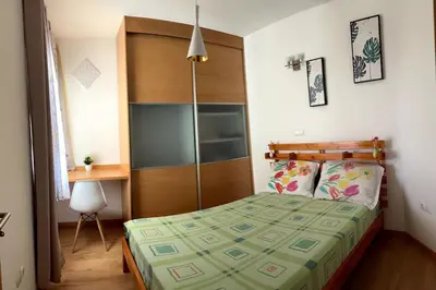 a bedroom with a bed with a wooden headboard and a desk at Casa So Morabeza in Mindelo
