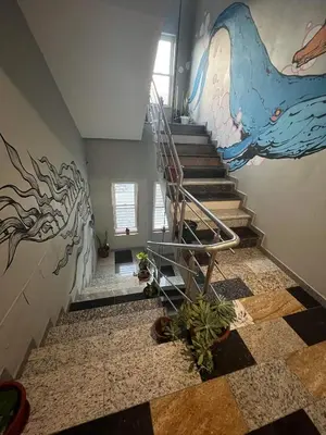 a staircase with a painting of a dolphin on the wall at Spencer Residencial APARTAMENTOS in Praia