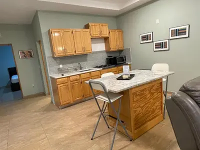 a kitchen with wooden cabinets and a counter top at Spencer Residencial APARTAMENTOS in Praia