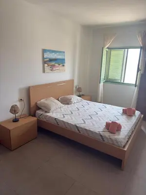 a bedroom with a large bed and a window at Djadsal Moradias in Santa Maria