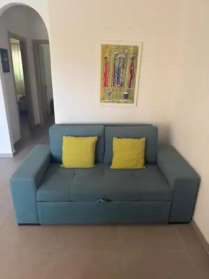 a blue couch with two yellow pillows in a living room at Djadsal Moradias in Santa Maria