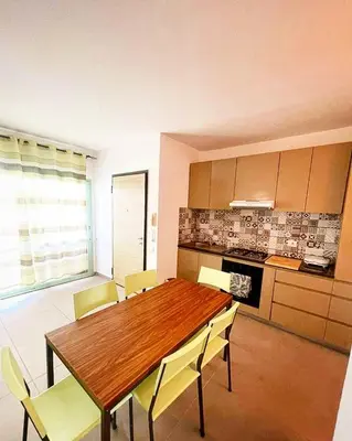 a kitchen with a wooden table and yellow chairs at Djadsal Moradias in Santa Maria